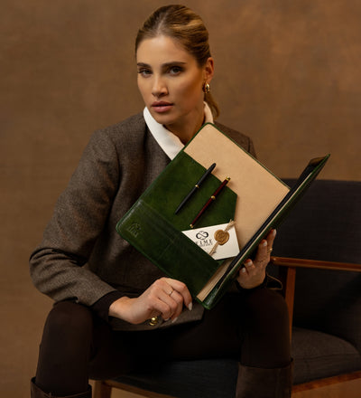 Woman displaying the open green Something Fresh portfolio with pens and a card inside